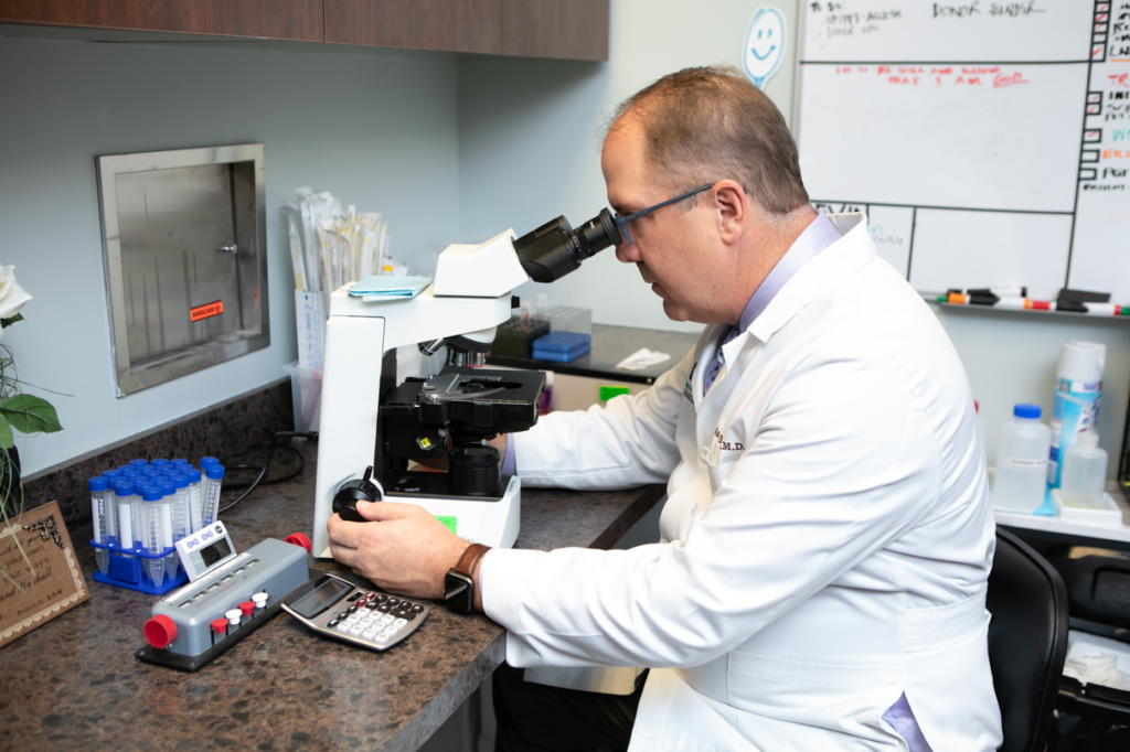 doctor brown looking through microscope